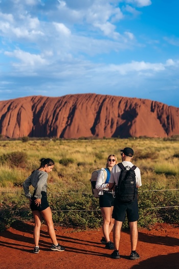 three friends watching uluru at sunset on a Rock The Centre tour
