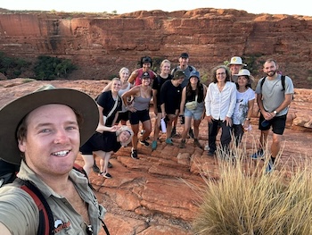 a group of friends taking a selfie with their tour guide in Uluru