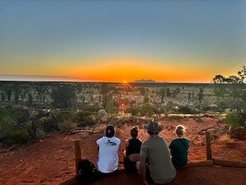 A group of friends enjoying sunset in the red centre on a rock the centre trip