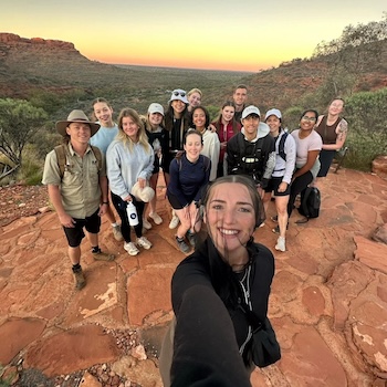 A group of backpackers taking a selfie in the red center on a rock the centre trip