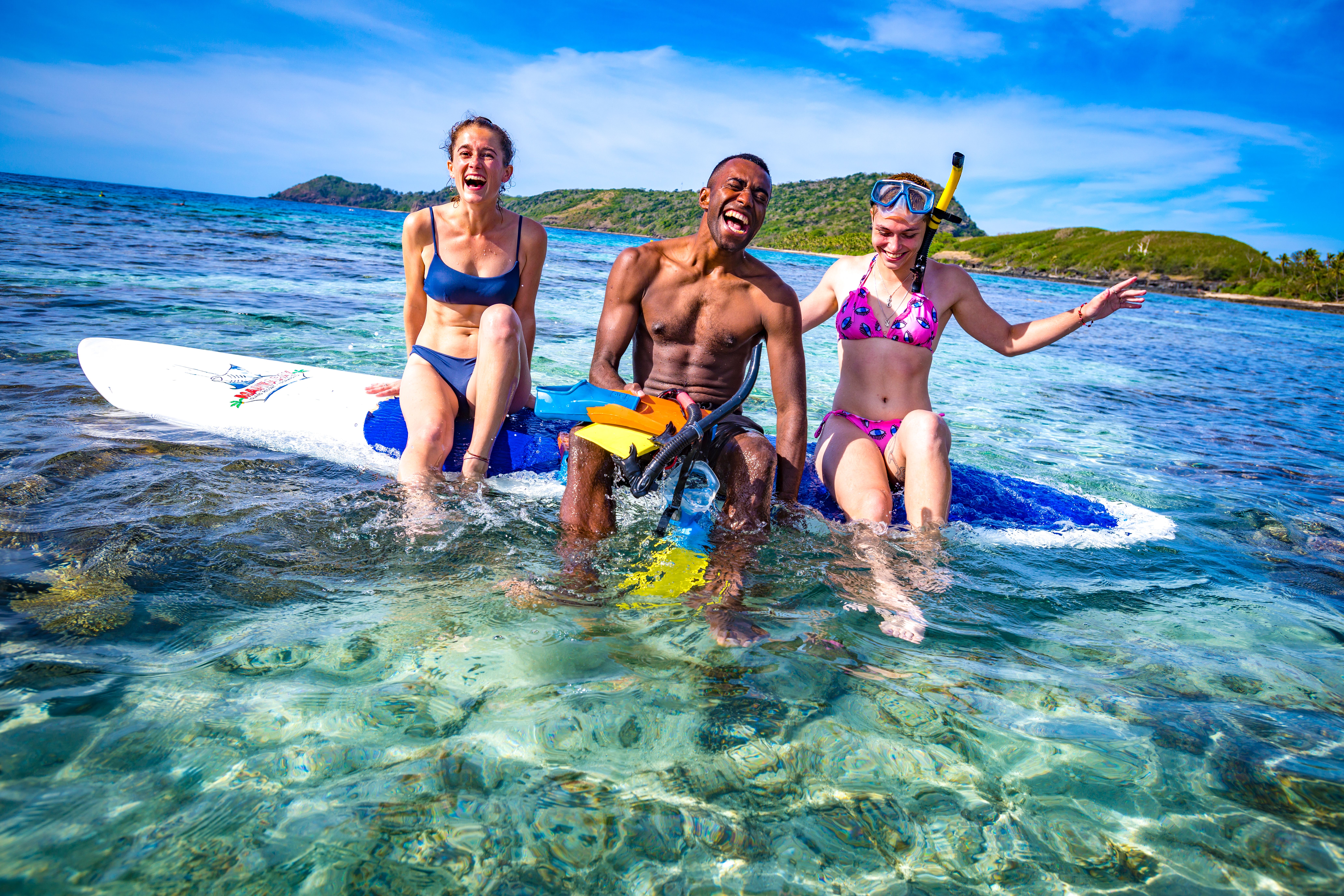 Image of Friends sitting on paddle boards in Fiji Sea