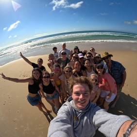 A group of backpackers having fun on 75 mile beach on K'gari Fraser Island taking a selfie