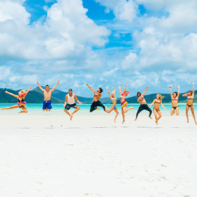 A group of friends on the beach jumping and having fun