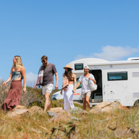 Four friends leaving a motorhome they rented from Peterpans and making their way to the beach. 