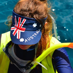 Image of a lady wearing a hat with the Australian Flag with a snorkel on the Great Barrier Reef 