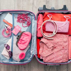 A pink suitcase full of packed items for a backpacker travelling the east coast of australia