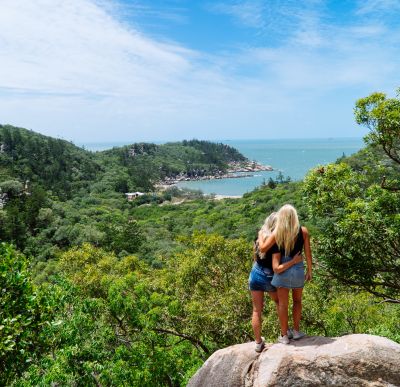 2 girls standing together and taking in the breathtaking rainforest and ocean