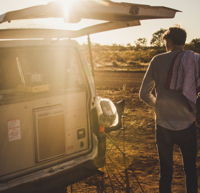 Man with his campervan setting up for the sunset