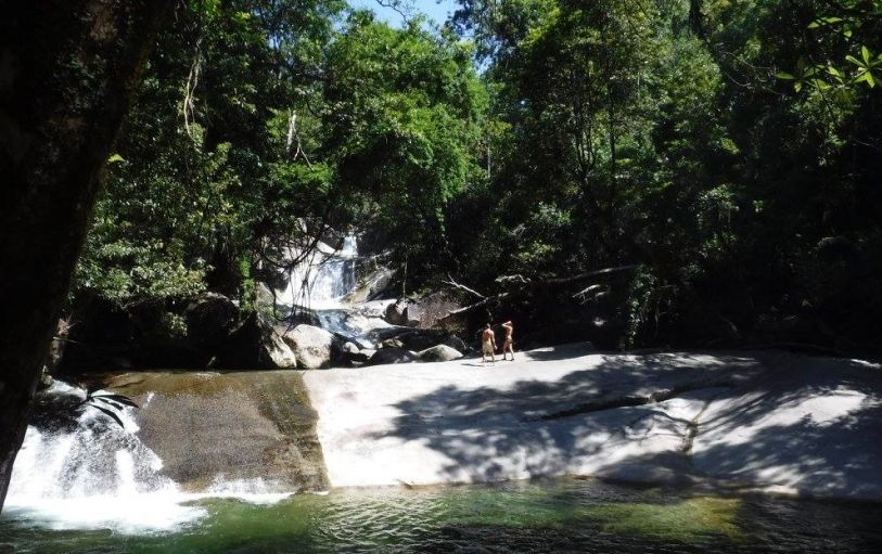 Group of friends wearing swimming costumes in front of the MilaMila waterfalls