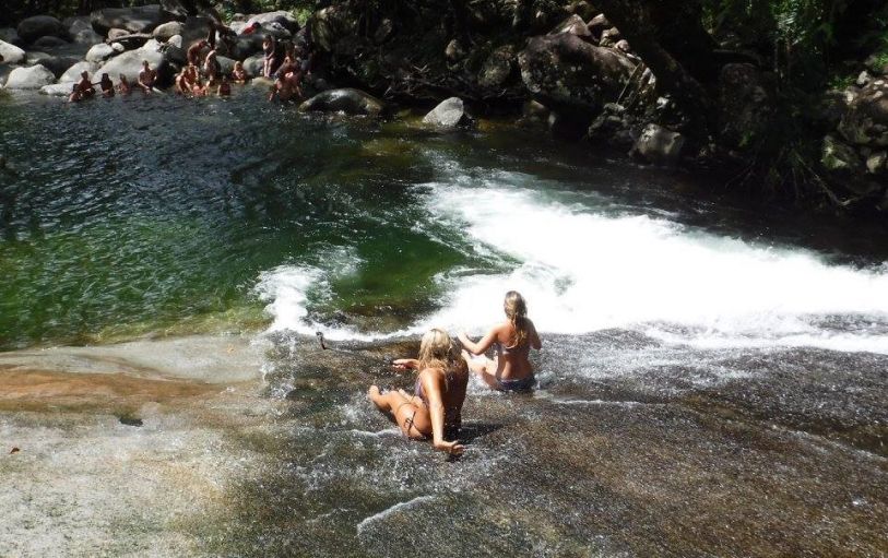 Group of friends wearing swimming costumes in front of the MilaMila waterfalls