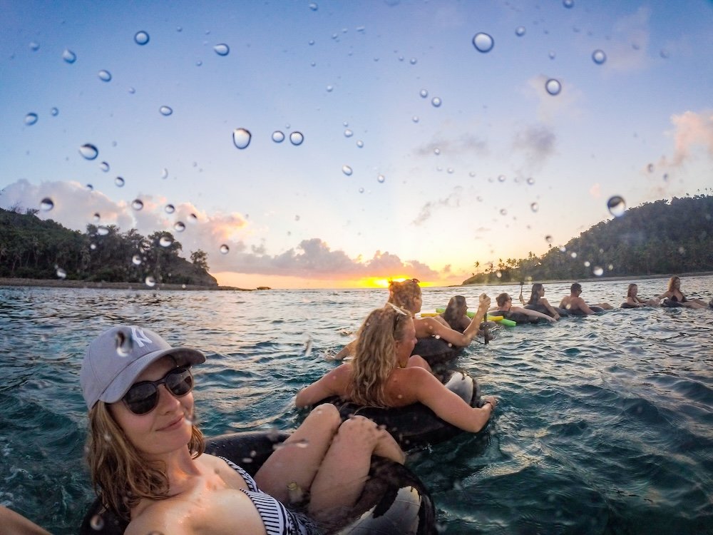 A group of backpackers sunset tubing  in Fiji having a great time