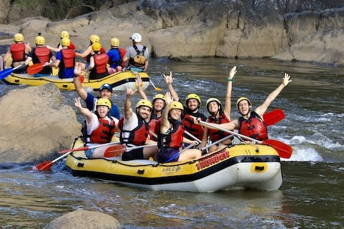 A group of backpackers in a yellow raft having fun on the Foaming Fury rafting trip on the Barron River