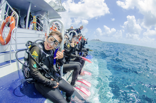 A group of backpackers in scuba diving gear ready to dive on the aquaquest great barrier reef day trip