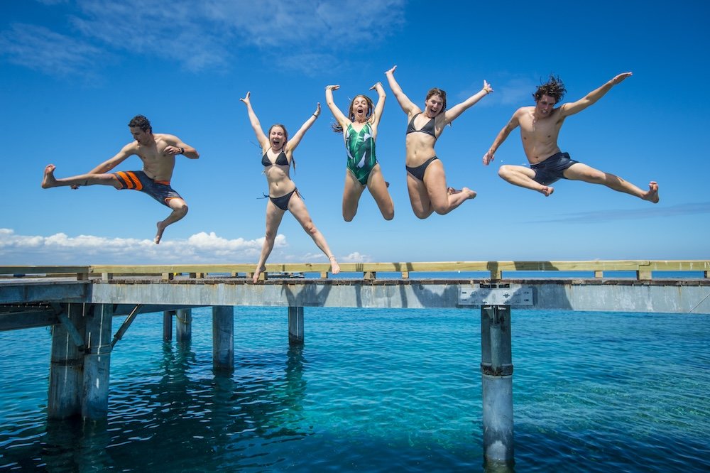 A group of friends having fun and Jumping off the Malamala Jetty in Fiji