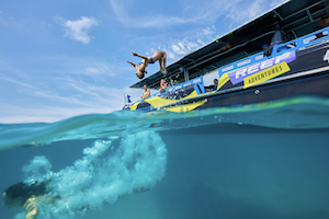 backpacker doing a flip off a purple boat on the Great Barrier Reef