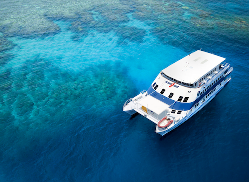 The Ocean Quest Liveaboard docked beside a reef on the Great Barrier Reef during an overnight trip