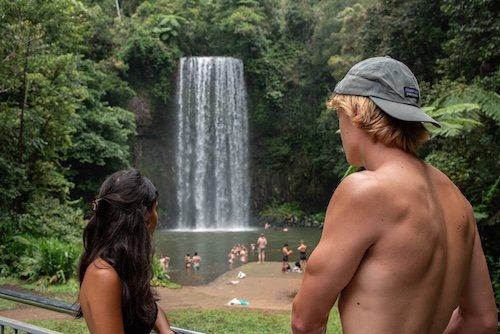 Two backpackers admiring the millaa milla falls waterfall during the Waterfall wanderers Day trip 